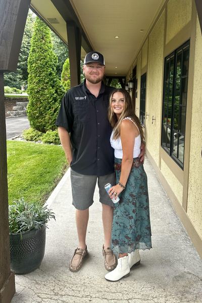 Alex and Hannah Duvall standing together outdoors; Alex wears a Many Parts, One Body shirt